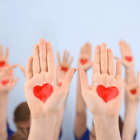 Handflächen mit aufgemalten Herzen